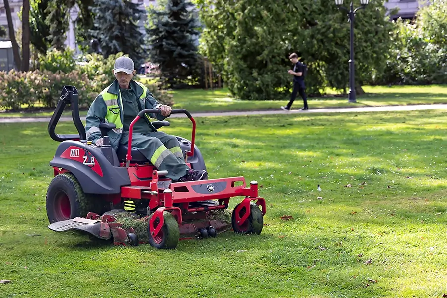 a lawn care professional mowing grasses while on a lawn tractor