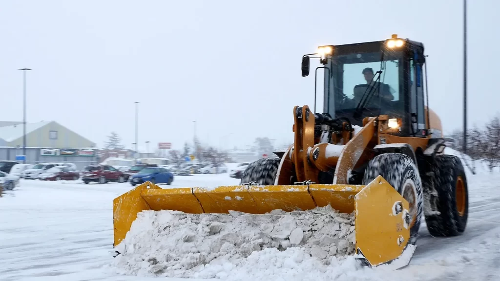 removing snow on the road with a large snowplow