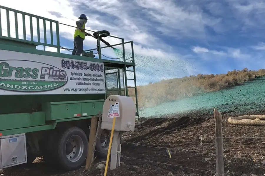 a landscape professional applying extensive hydroseed while on top of a truck