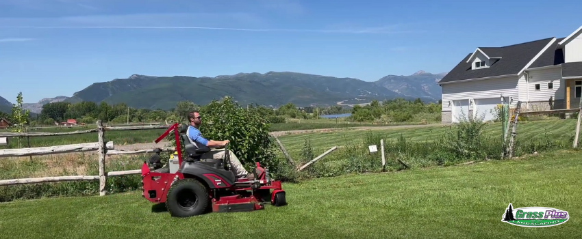 A lawn care technician riding a mower