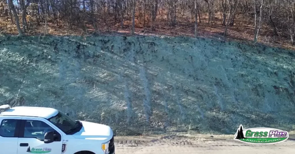 A pickup truck in front of a sloped landscape.